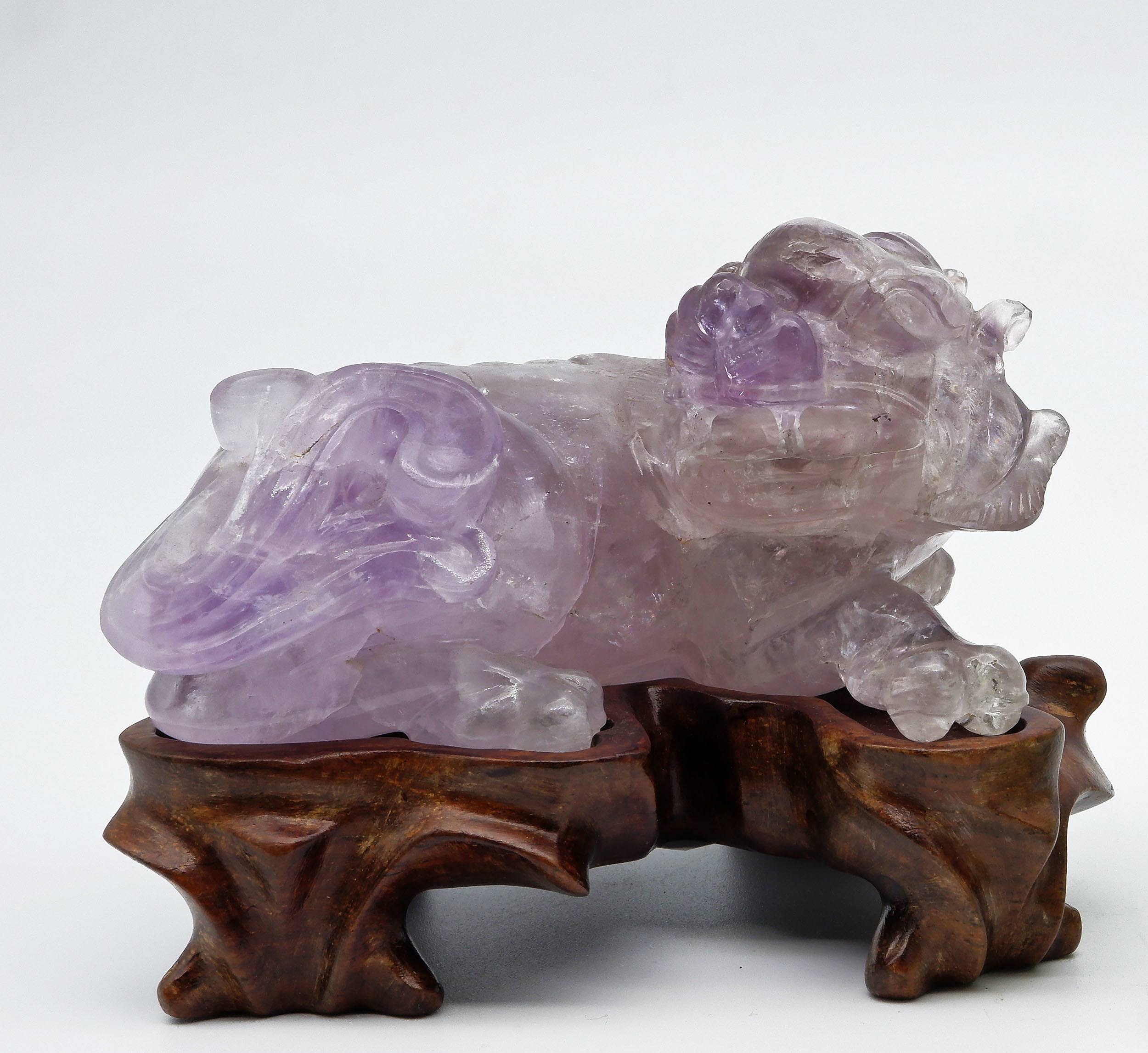 'Chinese Carved Amethyst Model of a Buddhist Lion on a Carved Hardwood Stand, 20th Century'